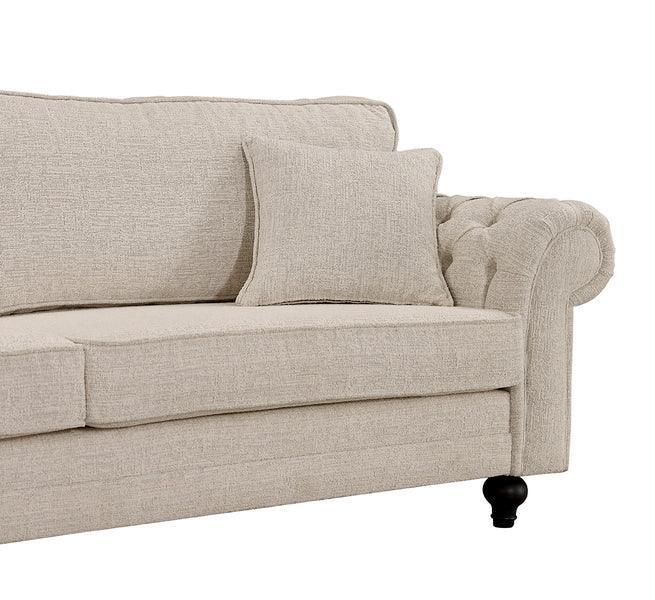 Beige fabric sofa with button-tufted armrest and matching cushion, close-up view