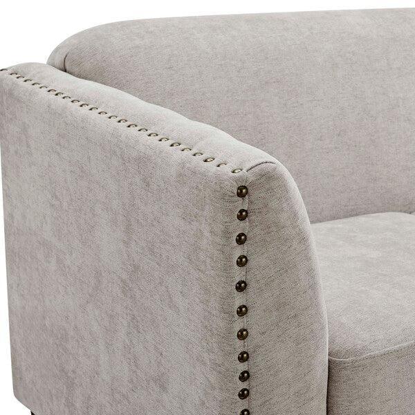 Light grey fabric sofa arm with metal stud detailing and soft upholstery
