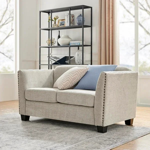 Light grey fabric sofa with studded arms and cushions in modern living room