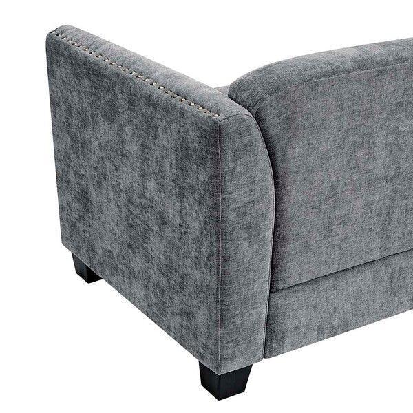 Grey fabric sofa armrest with nailhead trim detail and black legs