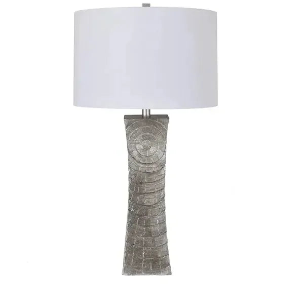 Silver textured table lamp with a white drum shade and curved geometric base