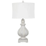 Distressed white table lamp with fluted urn-shaped base and white drum shade, front view