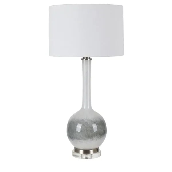 Modern table lamp with white drum shade and glass base on silver stand