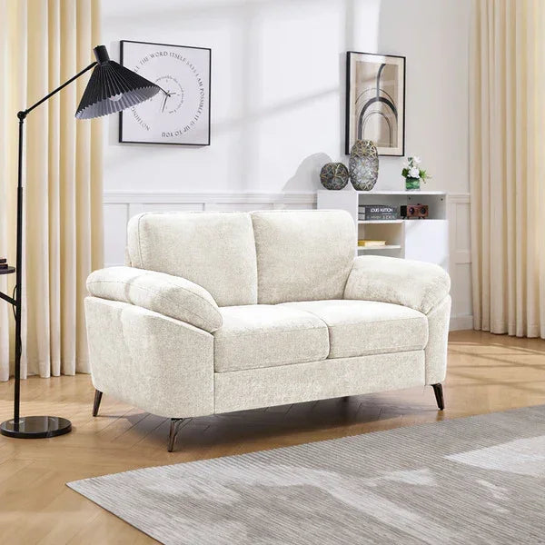 Beige fabric sofa with cushioned arms in modern living room with floor lamp and wall art