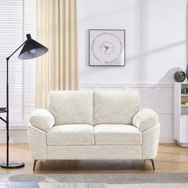Cream fabric sofa with plush cushions in bright living room next to black floor lamp