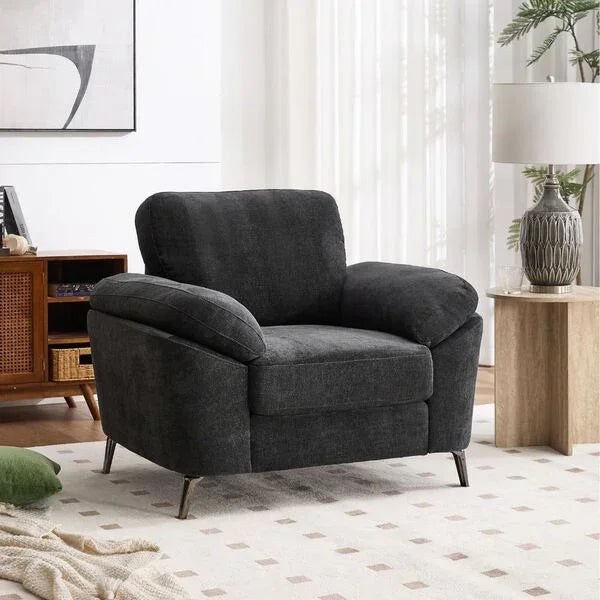Dark grey fabric armchair with pillow arms and angled metal legs in bright living room