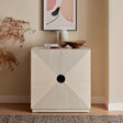 Modern sideboard with geometric striped doors, decorative bowl, books, and framed wall art