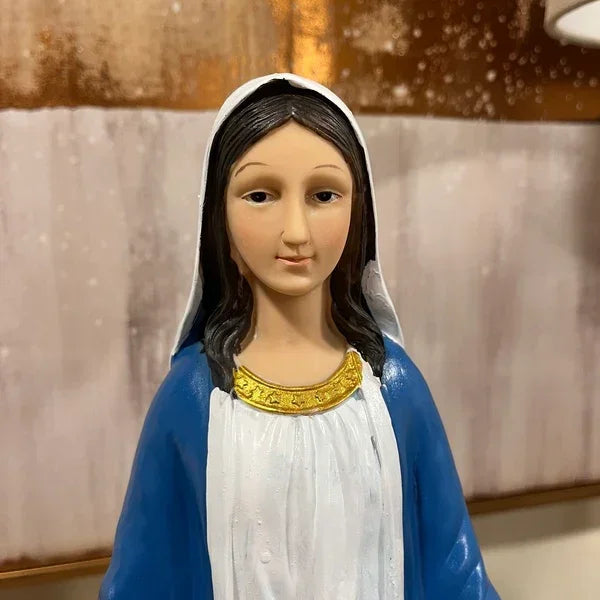 Religious statue with blue and white robe and gold collar, displayed indoors