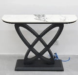 Marble top console table with black geometric base against a white wall