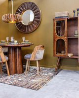 Wooden dining table and chairs with glass cabinet and round mirror in dining room
