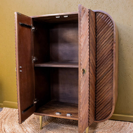Wooden cabinet with chevron pattern doors open showing interior shelf