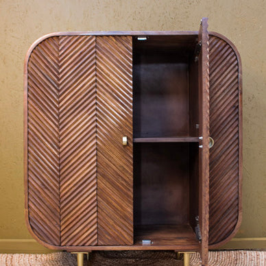 Wooden cabinet with chevron pattern doors, one door open showing two shelves