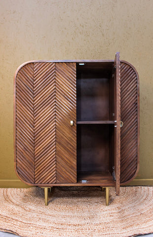 Wooden cabinet with chevron pattern doors, one door open showing two shelves