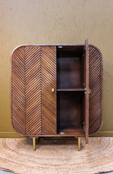 Wooden cabinet with chevron pattern doors, one door open showing two shelves