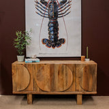 Wooden sideboard with oval door designs against dark wall with lobster artwork