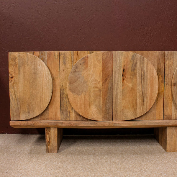 Wooden sideboard with circular carved doors on carpeted floor
