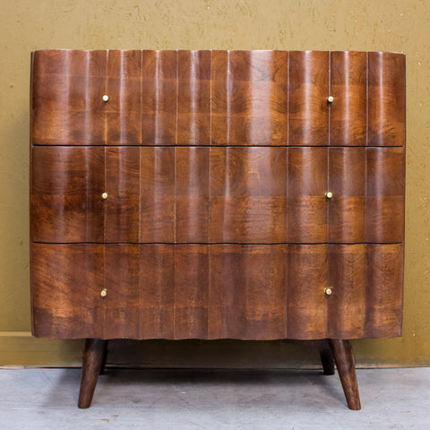 Wooden three drawer cabinet with curved fronts and small round knobs