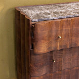 Close-up of wooden cabinet drawers with brass handles and marble top