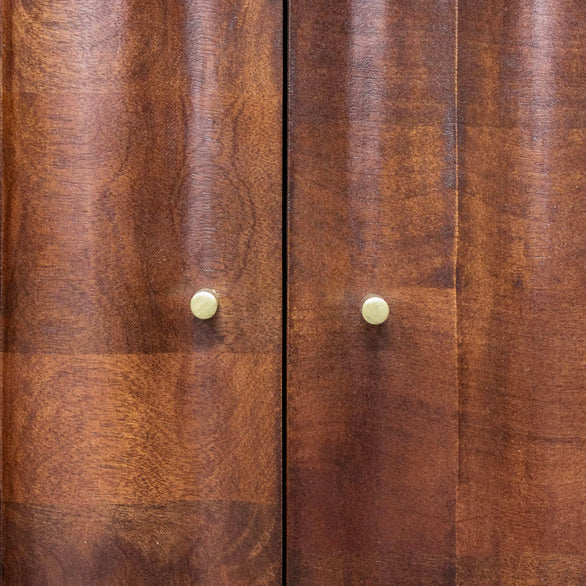 Close-up of wooden cabinet doors with round brass handles