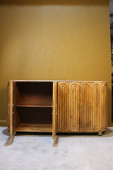 Wooden sideboard with two open doors showing internal shelving and capsule design panels