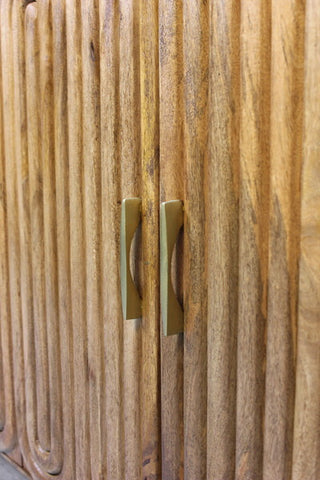 Wooden cabinet doors with vertical capsule-shaped grooves and brass handles