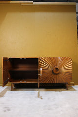 Wooden sideboard with one door open showing interior shelf and sunburst carved door design
