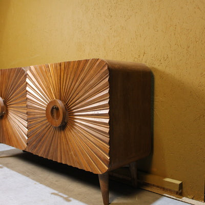 Brown sideboard with carved circular sunburst wooden doors on short legs