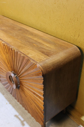 Side view of wooden sideboard with detailed circular carved door design