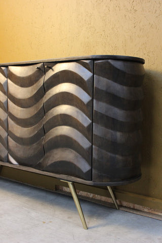 Curved wooden cabinet with wavy carved doors and angled metal legs
