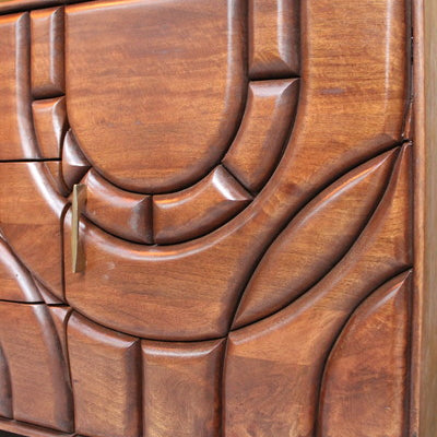 Close-up of wooden cabinet door with abstract carved geometric patterns