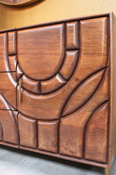 Close-up of wooden cabinet door with abstract carved geometric patterns