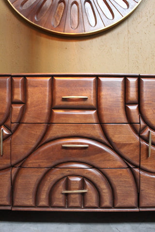 Wooden sideboard with carved geometric pattern and brass handles
