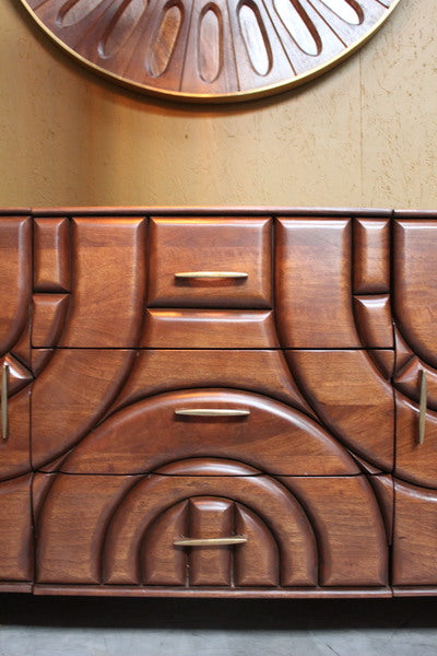 Wooden sideboard with carved geometric pattern and brass handles