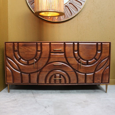 Wooden sideboard with two doors and three drawers featuring curved carved designs