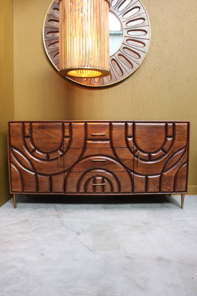 Wooden sideboard with two doors and three drawers featuring curved carved designs