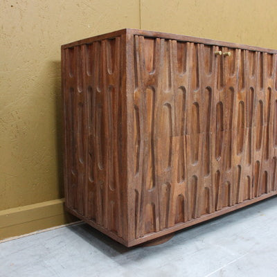 Brown sideboard with carved retro pattern on wooden doors and brass handles