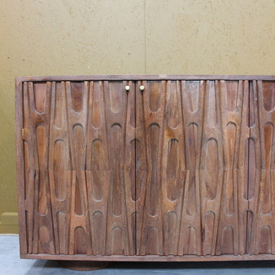 Wooden sideboard with carved abstract design and two small round handles