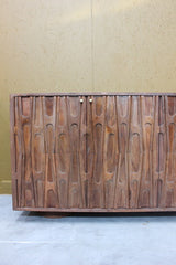 Wooden sideboard with carved abstract design and two small round handles