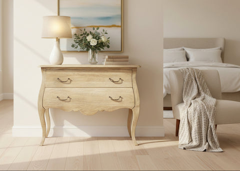 Curved wooden chest with two drawers, lamp, flowers and books on top