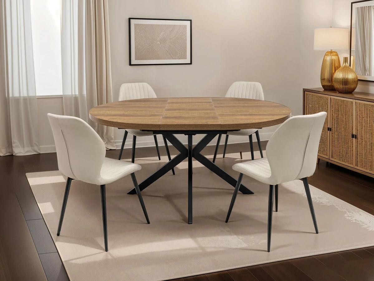 Round wood dining table with black metal legs and four white chairs in modern dining room