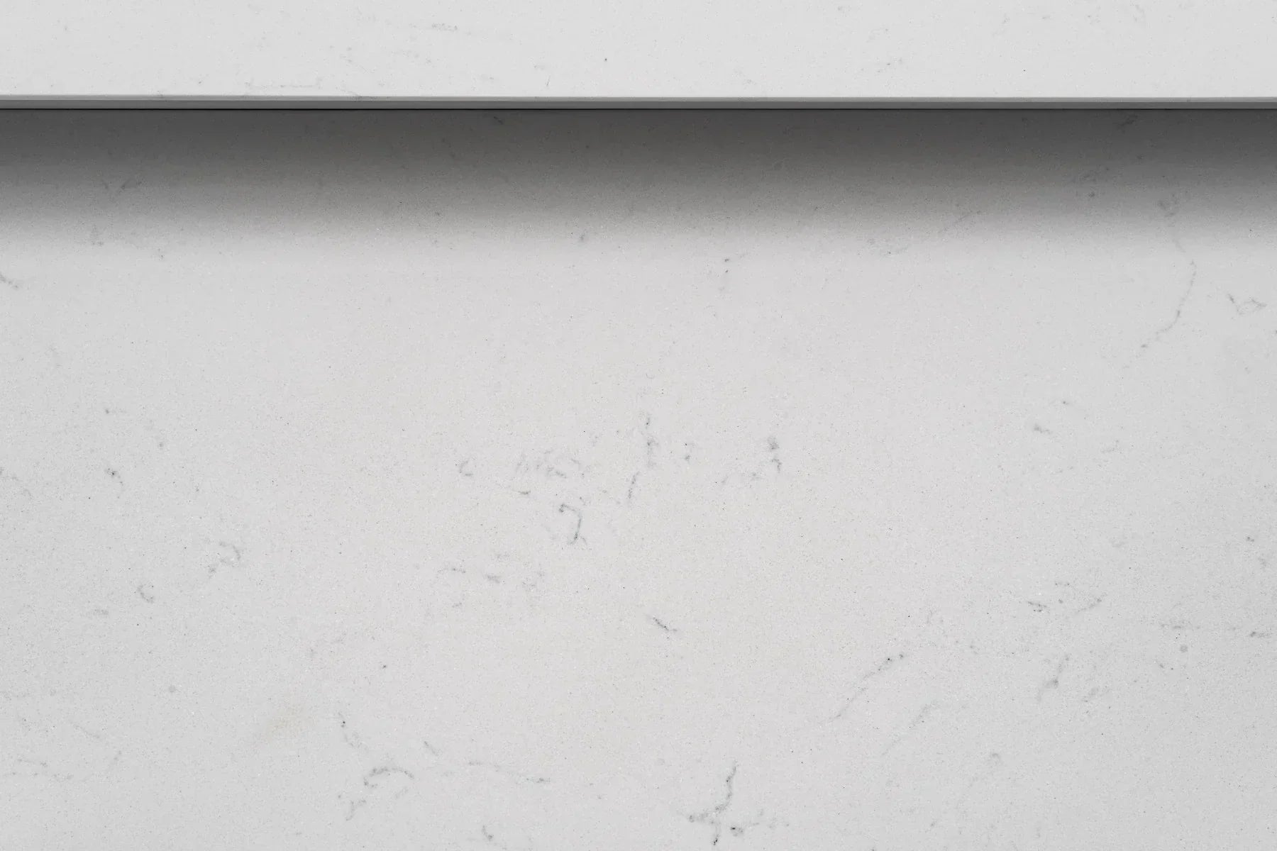 Closeup of white quartz tabletop with subtle grey veining detail