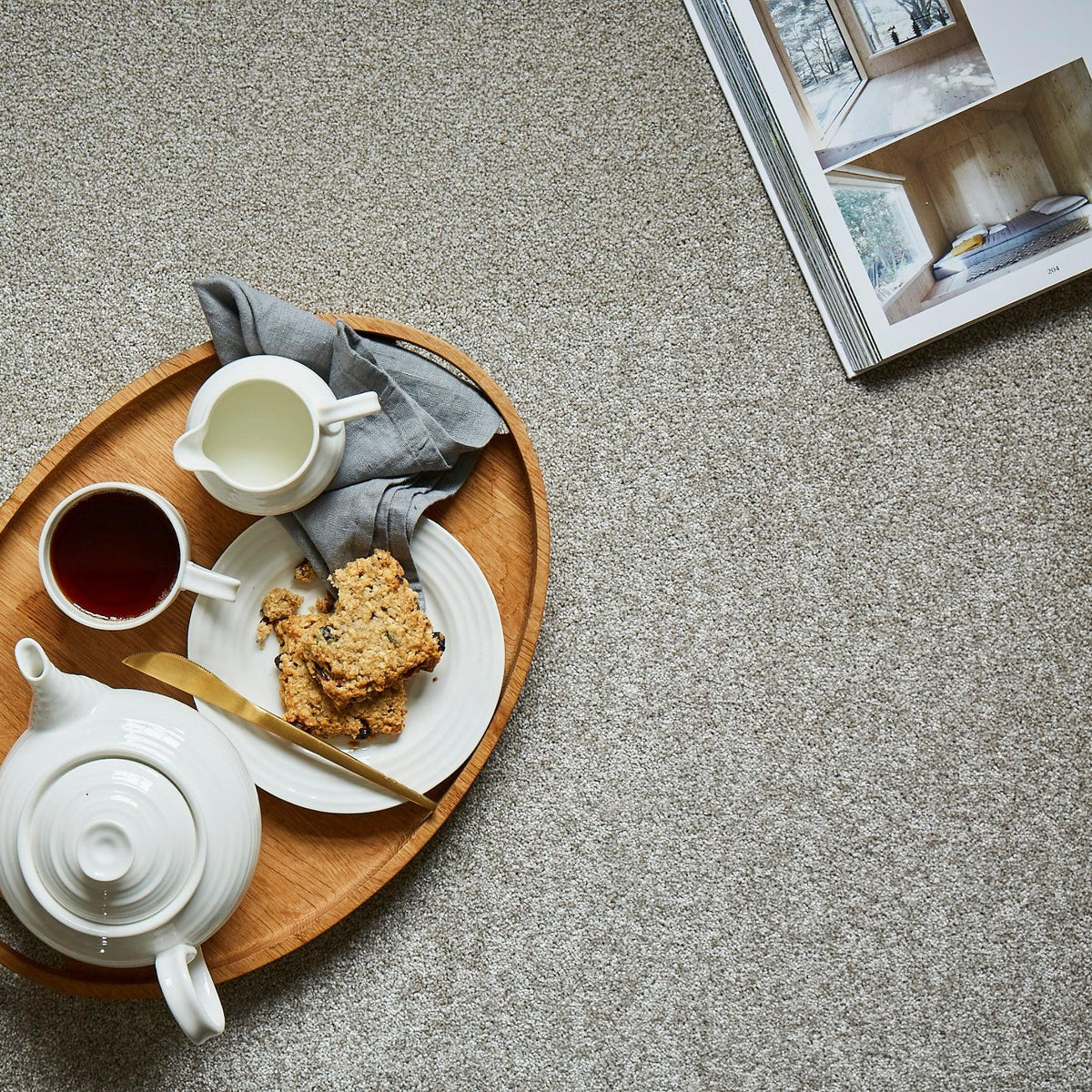 Light grey carpet with soft, textured pile styled with a wooden tray and tea set