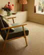 Green textured armchair with wooden frame in cozy living room setting