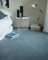 Soft blue carpet in a bedroom with a smooth, even texture and a modern side table.
