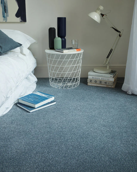 Soft blue carpet in a bedroom with a smooth, even texture and a modern side table.