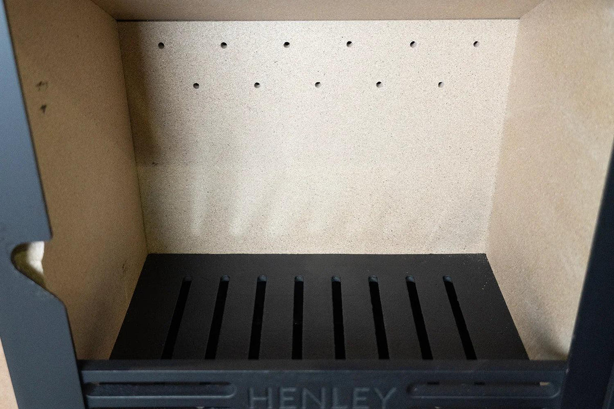 Inside view of stove firebox with heat-resistant brick lining and black metal grate