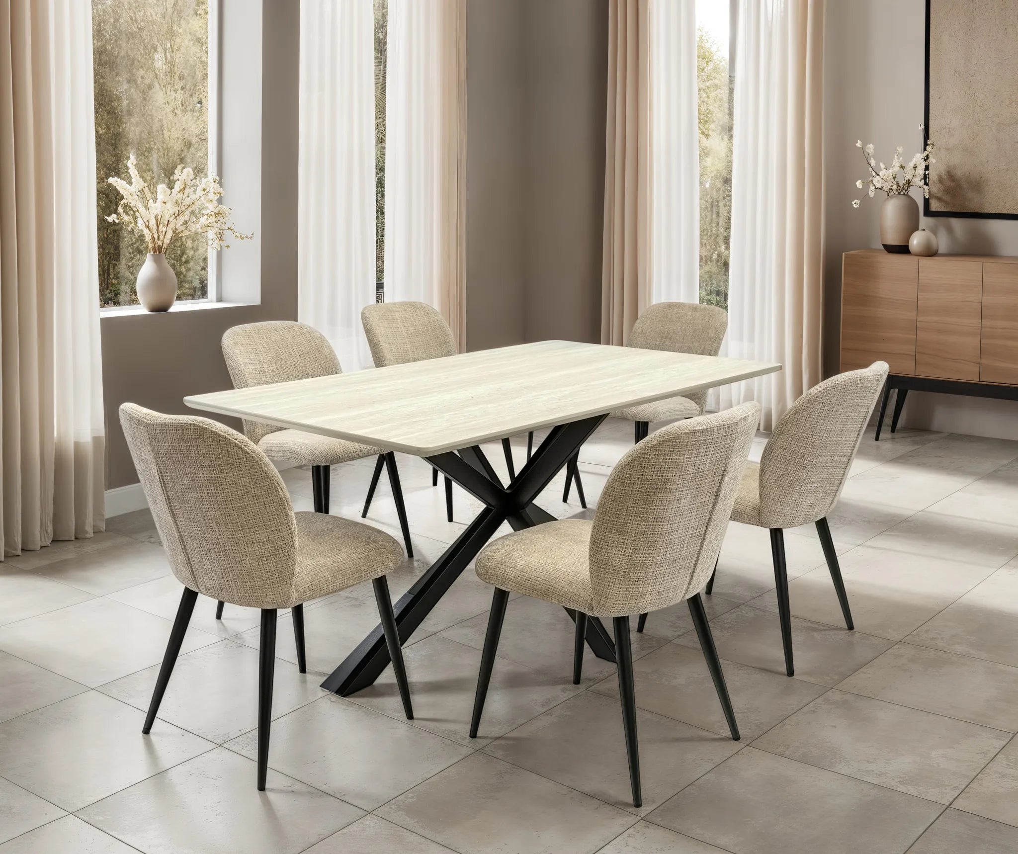 A modern dining set featuring a rectangular light wood table with a black X-shaped base and six upholstered dining chairs in a neutral beige fabric, set in a bright, contemporary dining room.