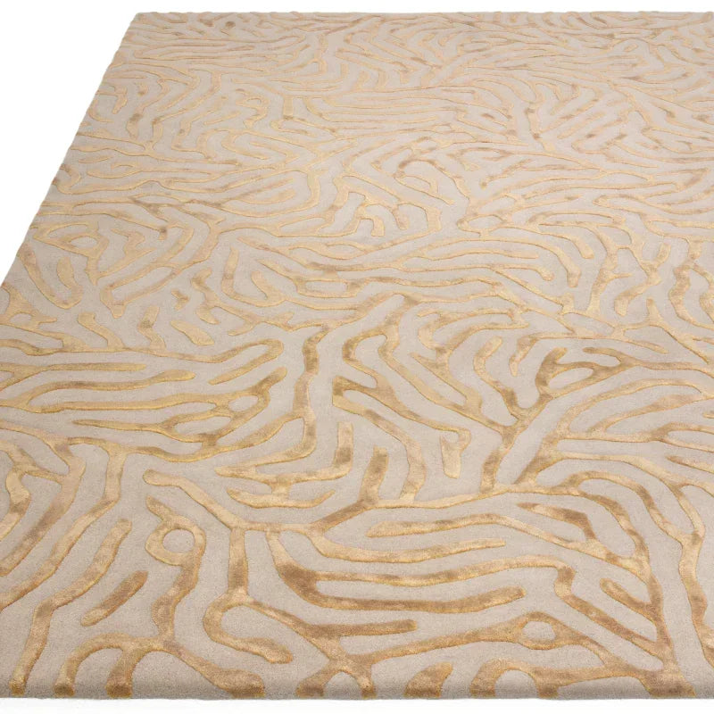 Beige and gold rug with abstract textured pattern, closeup of surface detail