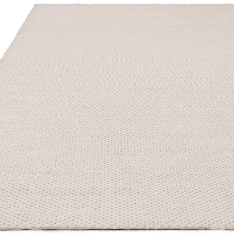 Cream wool rug with textured knit pattern shown from low angle