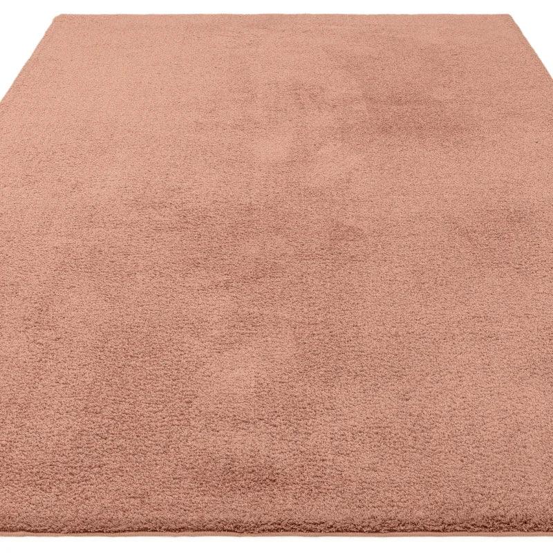 Blush pink area rug with soft texture and rectangular shape, shown from front angle